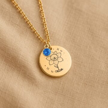 Personalized December carnation and birthstone necklace displayed on a neutral fabric background