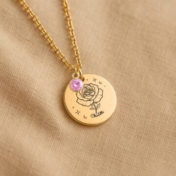 Personalized June carnation and birthstone necklace displayed on a neutral fabric background