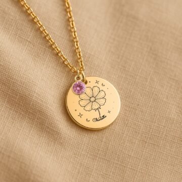 Personalized October carnation and birthstone necklace displayed on a neutral fabric background