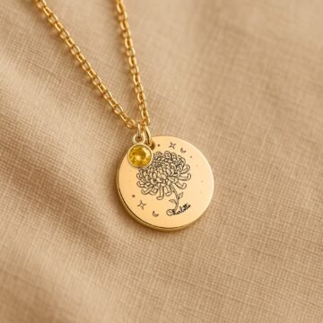Personalized november carnation and birthstone necklace displayed on a neutral fabric background