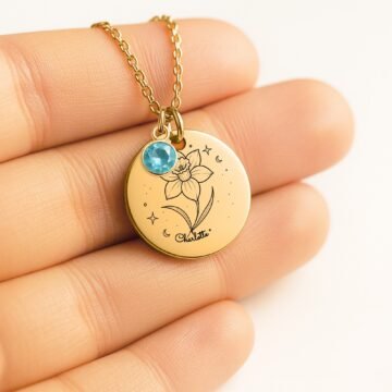 Personalized daffodil pendant necklace shown in hand for scale