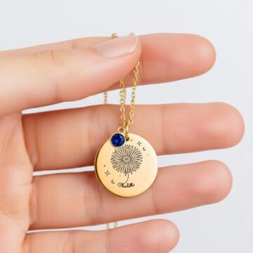 september carnation coin necklace held in hand to show the 20 millimeter pendant size